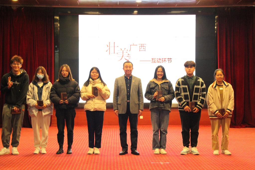 图为吴郭泉为现场互动学生进行颁奖并合照留念